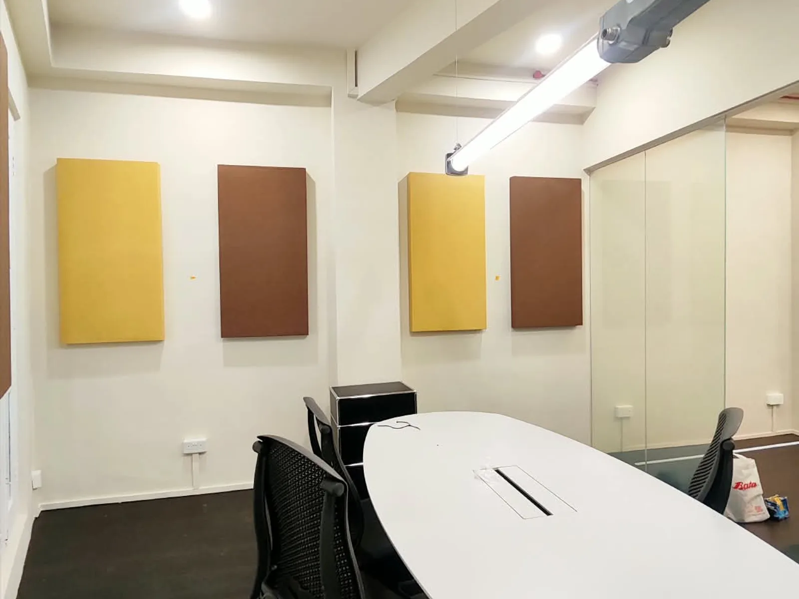 Fabric-wrapped acoustic wall panels installed in a corporate meeting room — commercial office acoustics project, Singapore